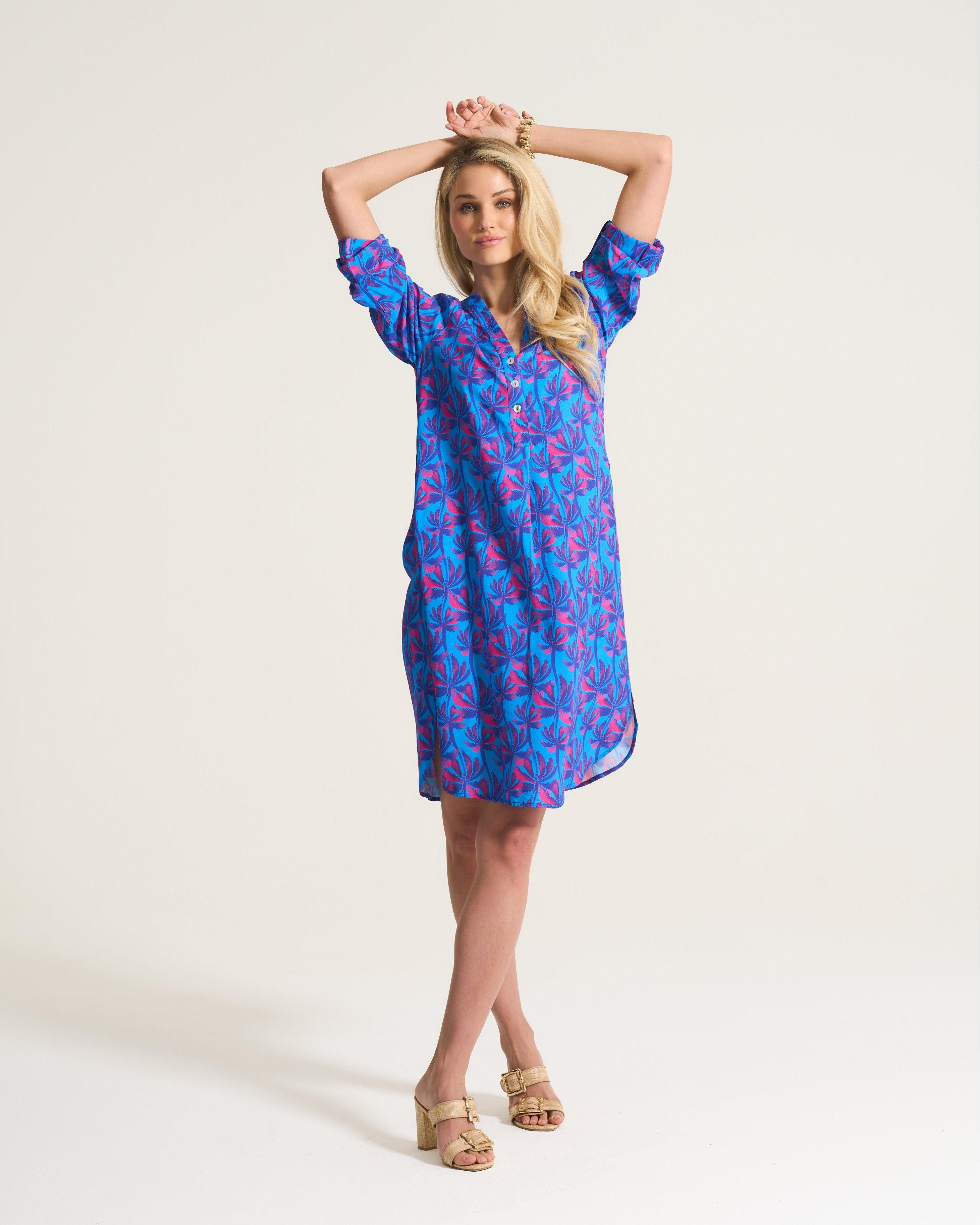 Woman wearing a blue floral dress against a white background
