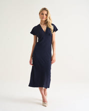 Woman wearing a navy blue dress on a white background