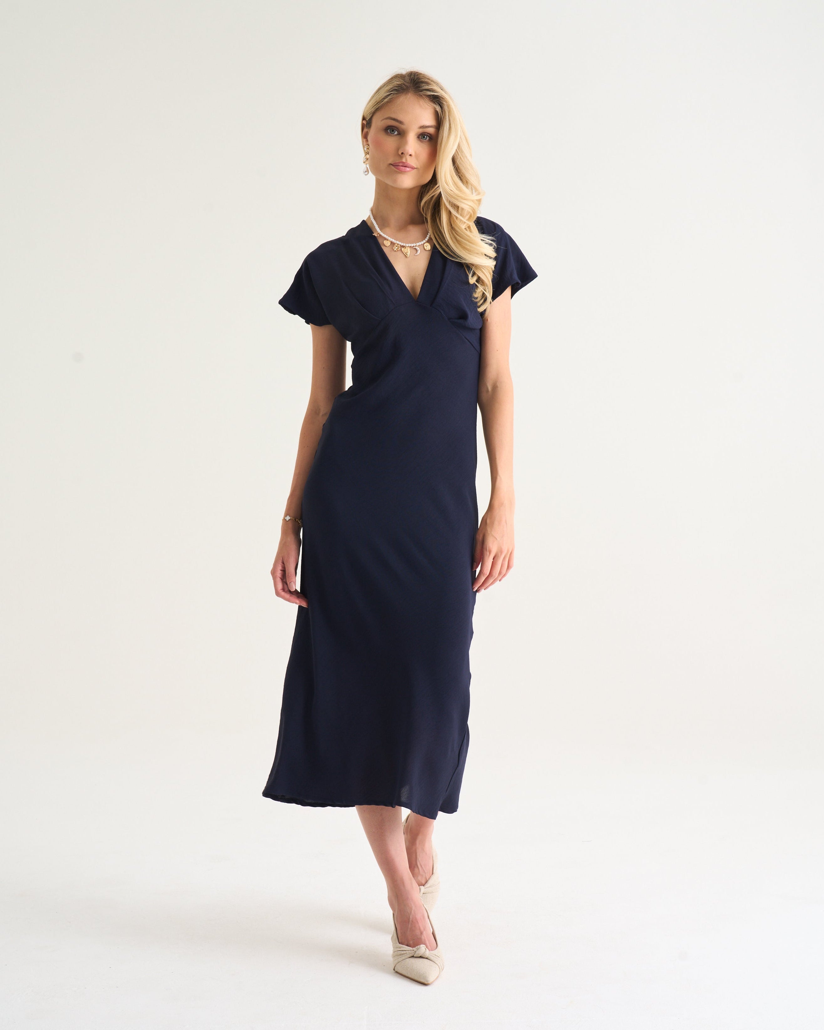 Woman wearing a navy blue dress on a white background